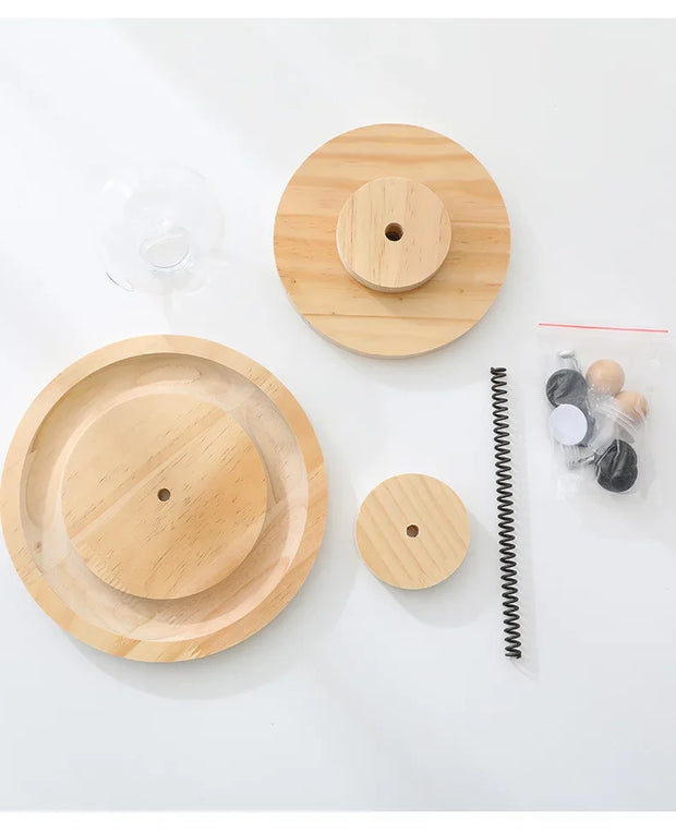 Solid wood components of an interactive cat turntable, featuring a spring and accessories for engaging feline play.